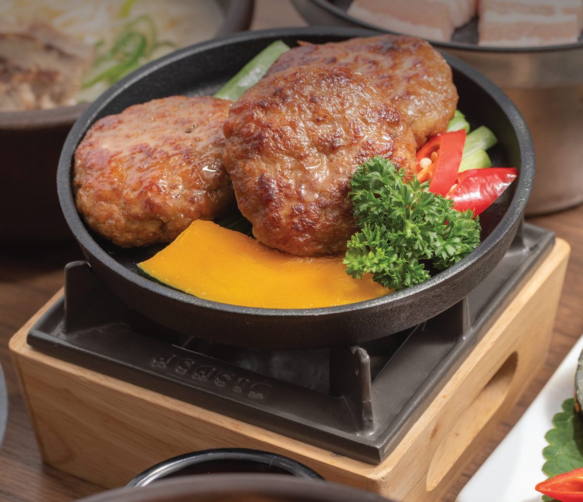Tteokgalbi patties on a cast-iron pan over a table stove